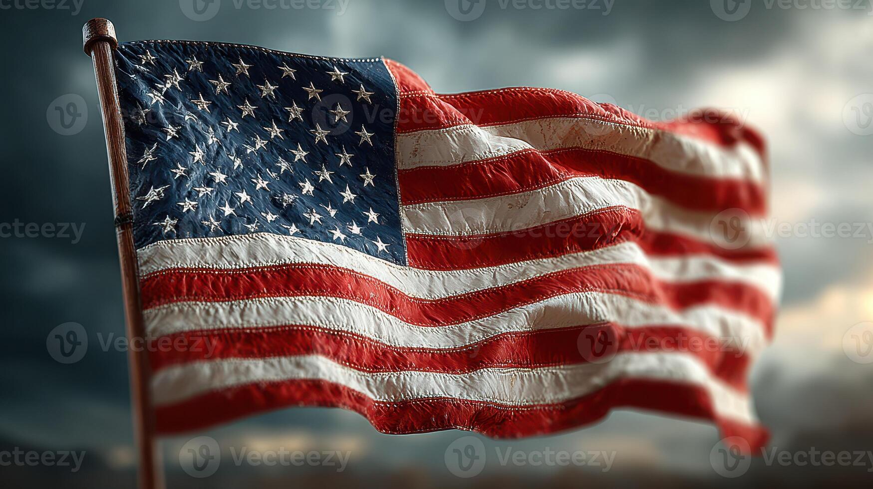 American flag waving in the wind against a dramatic cloudy sky during the late afternoon photo