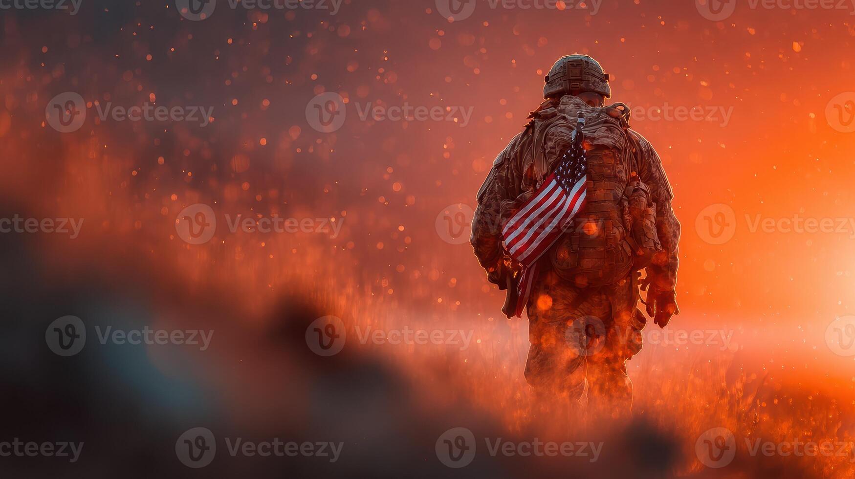 Soldier walking through smoke and fire at sunset carrying American flag photo