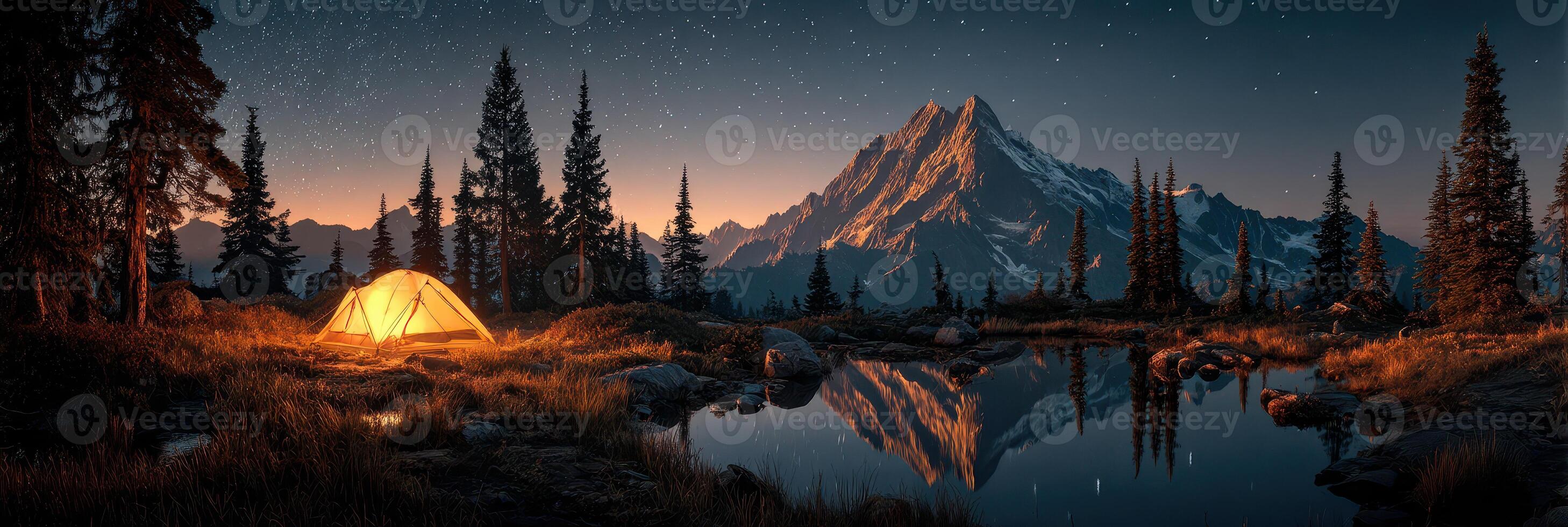 Tent lit by warm glow next to tranquil lake under starry sky in mountain landscape at dusk photo