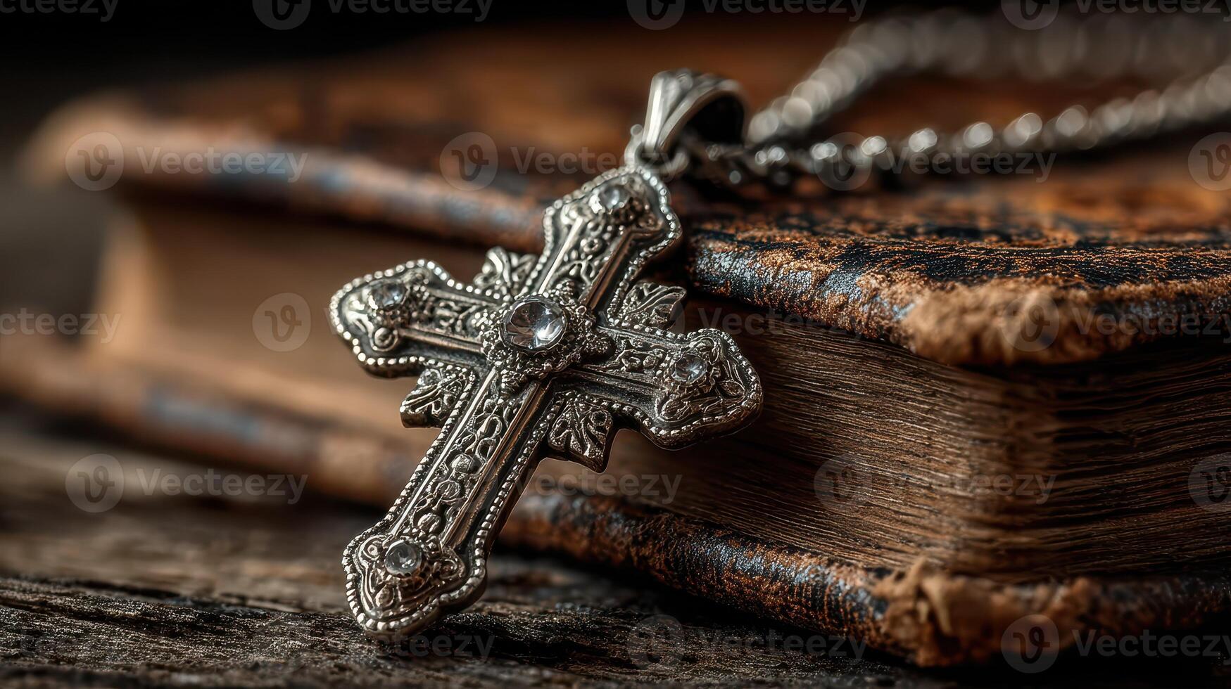 Detailed silver cross pendant resting on an antique leather-bound book in warm light photo