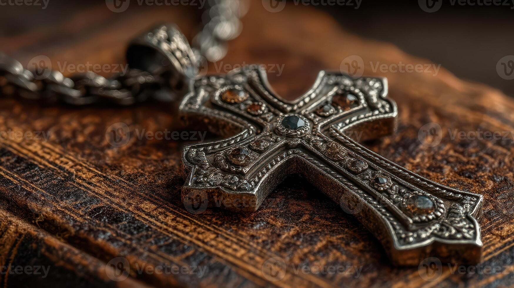 Intricate silver cross pendant resting on an antique book in soft light creating a serene and contemplative atmosphere photo