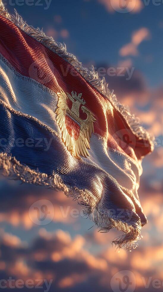 Flag of a nation waving in the wind at sunset with dramatic clouds in the background photo