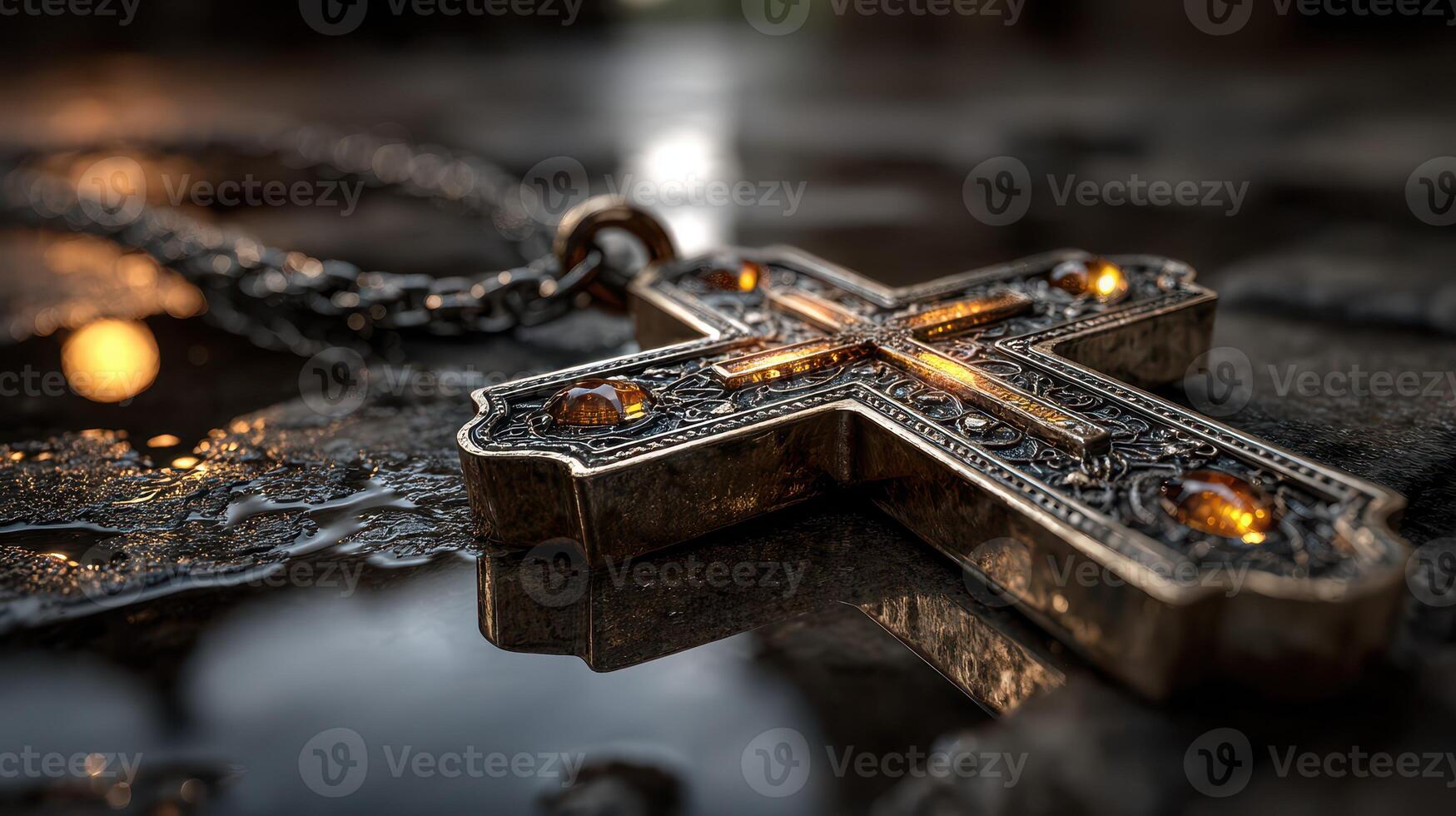 Intricate silver cross pendant with gemstones resting on a reflective surface showcasing detailed craftsmanship at sunset photo