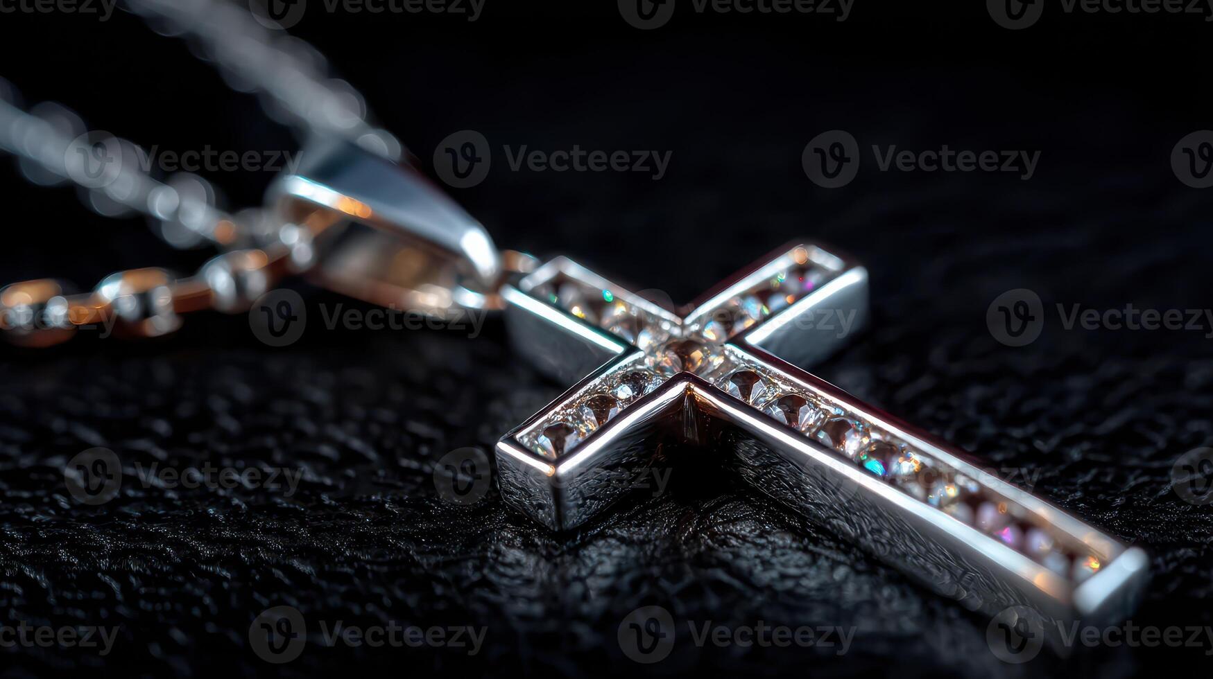 Shining silver cross pendant with sparkling stones on a black leather background photo