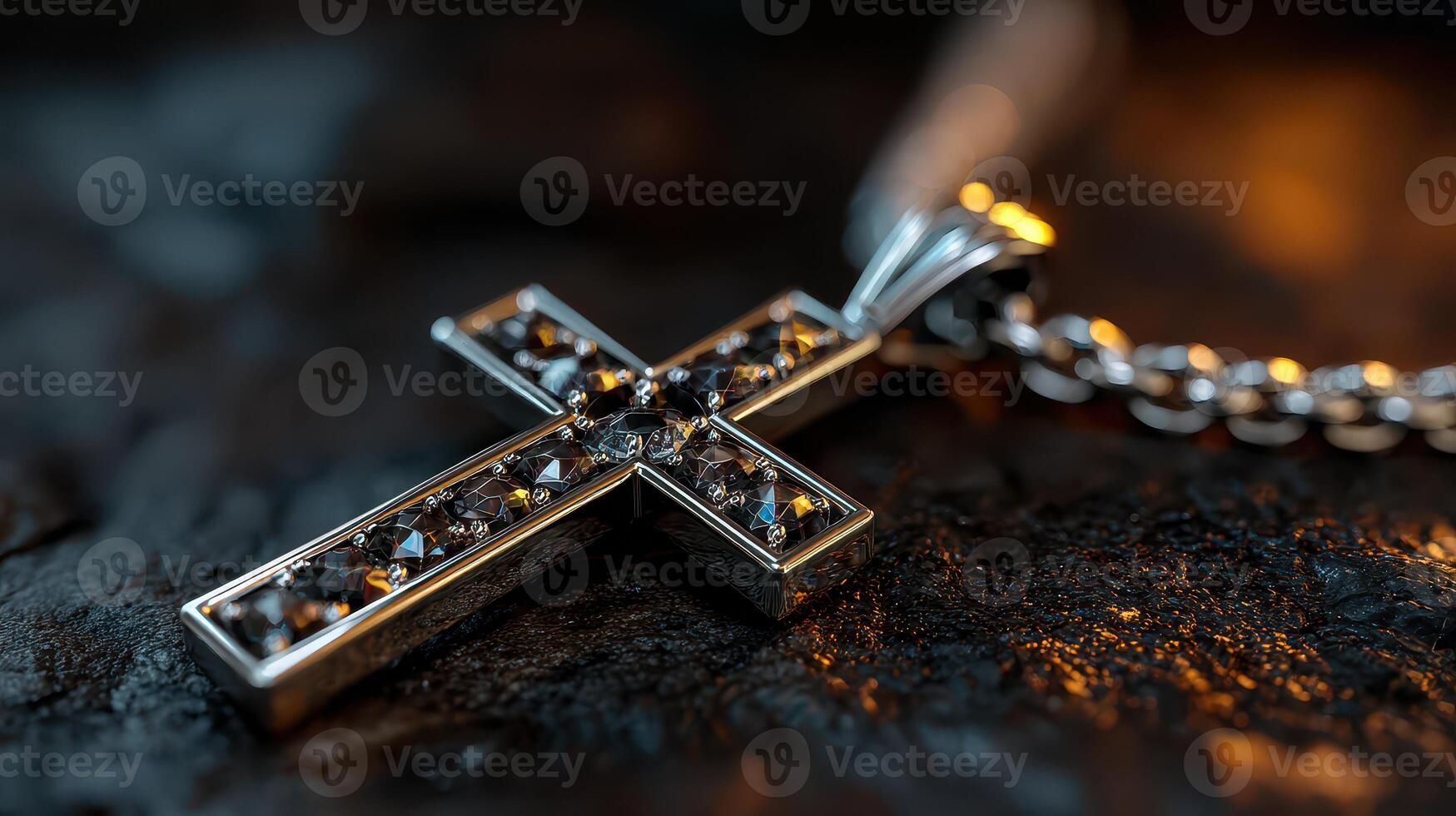 Silver cross necklace with sparkling gemstones displayed on textured surface during low light setting photo