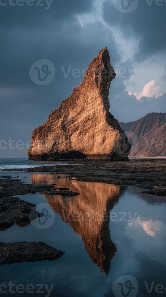Unique rock formation reflects in tidal pool during twilight at coastal landscape photo