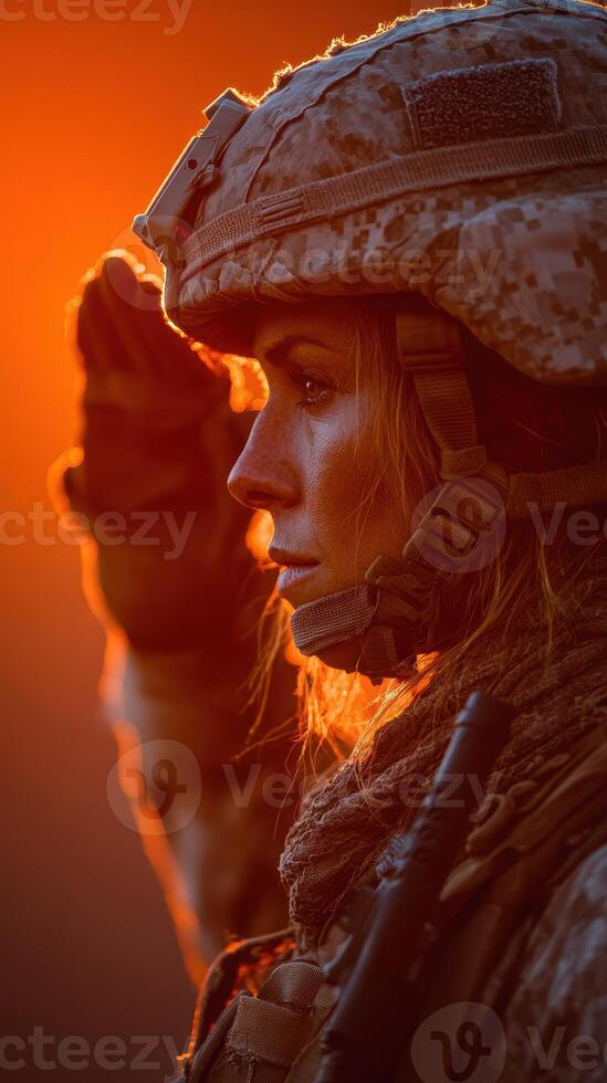 Military service member saluting at sunset in a dramatic display of respect and honor photo