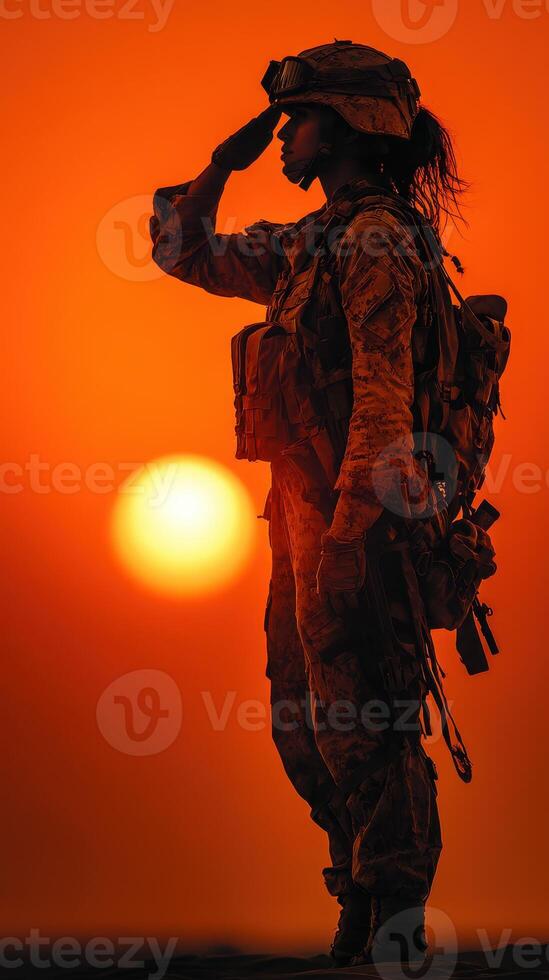 Soldier salutes at sunset with vibrant orange sky in the background representing honor and dedication photo