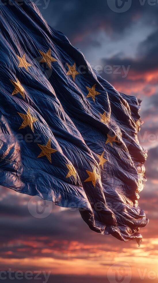 European Union flag waves against a dramatic sunset sky with clouds and vibrant colors photo