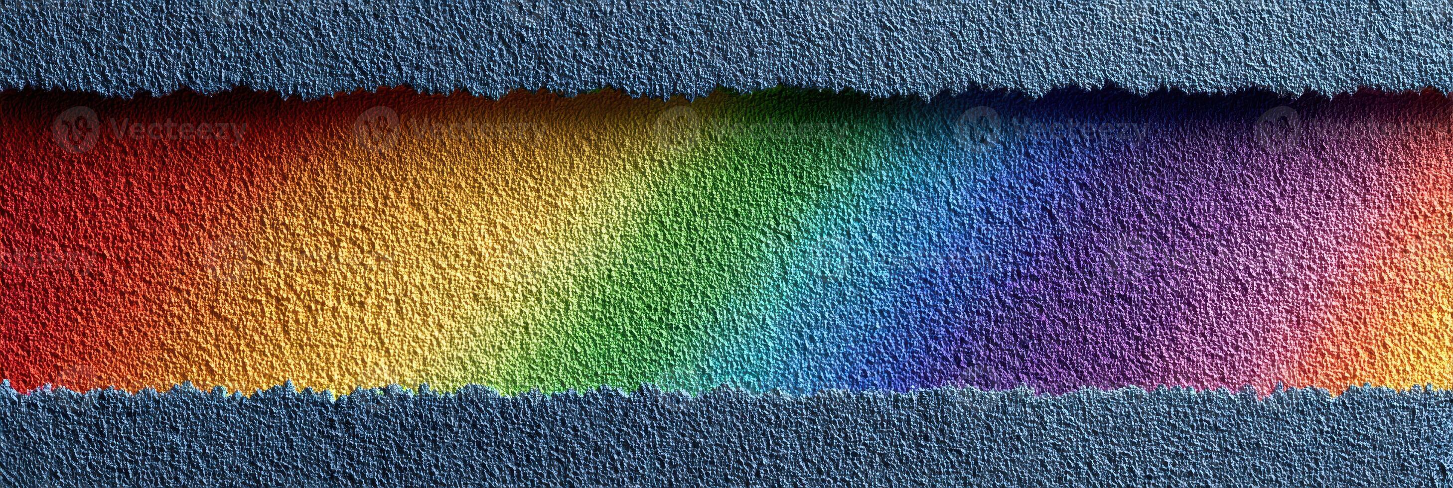 Colorful rainbow pattern on textured paper displayed against a blue background, showcasing vibrant hues and paper edges photo