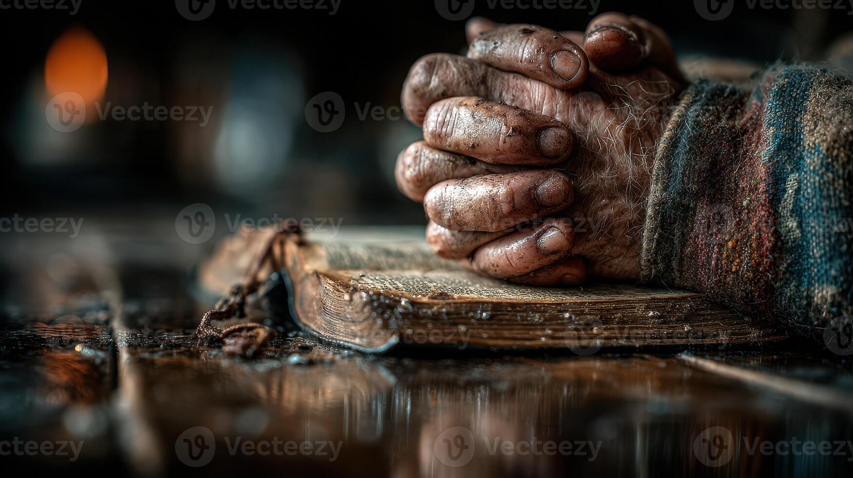 Hands clasped over an old book resting on a wooden table in a dimly lit room filled with history photo