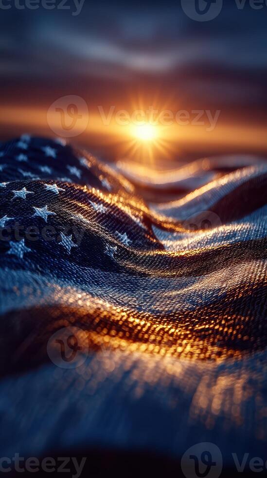 Sunset illuminating an American flag draped across waves of fabric in a serene landscape photo