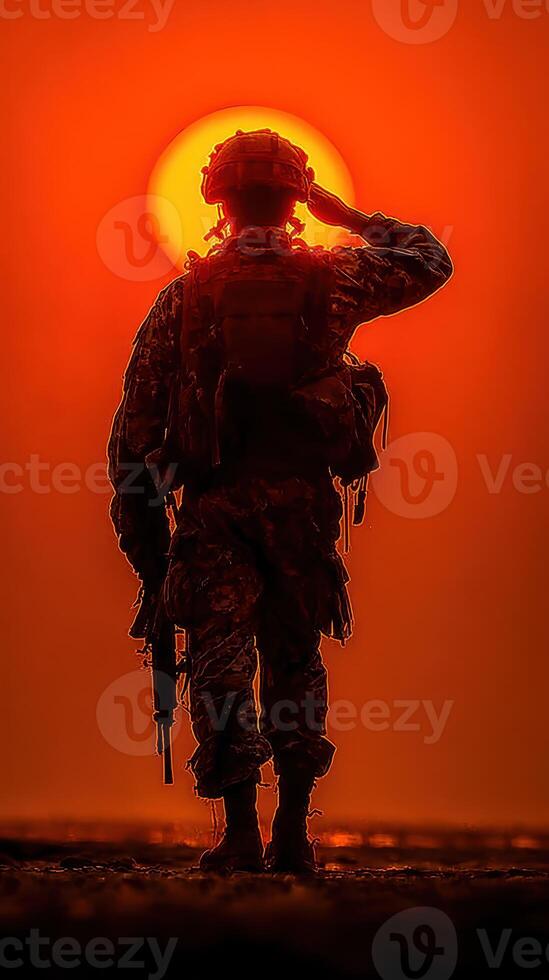 Soldier saluting against a striking sunset backdrop at a military base during late evening hours photo