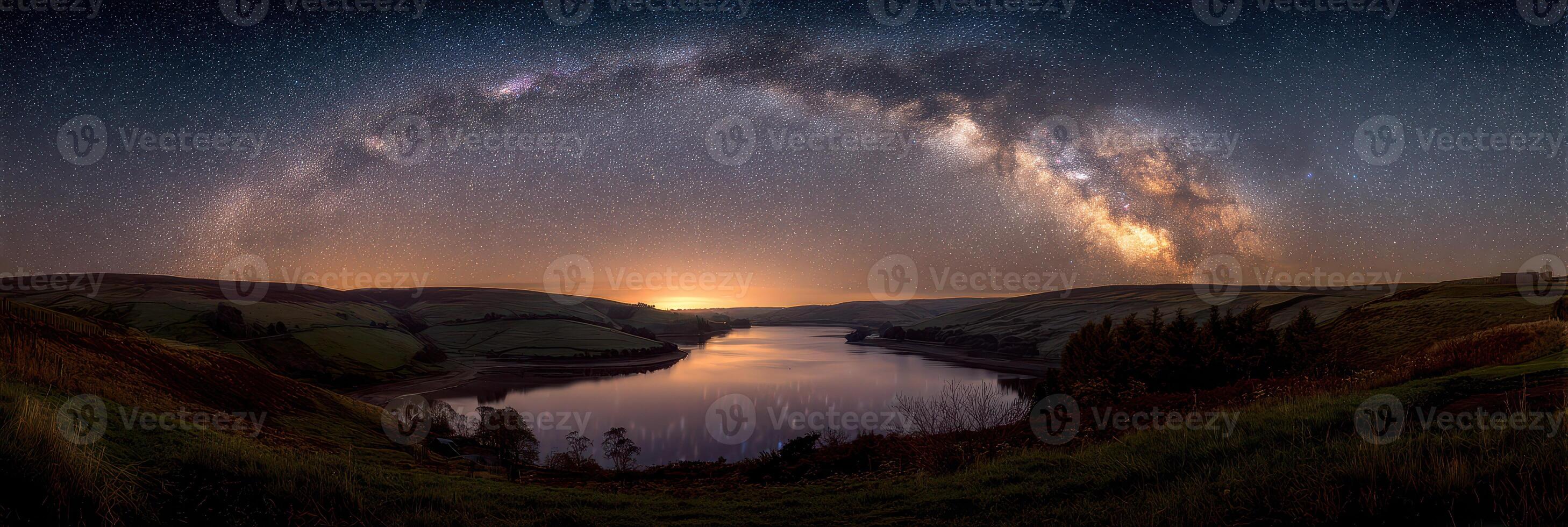 Stunning view of the Milky Way arching over a serene lake at dusk near rolling hills photo