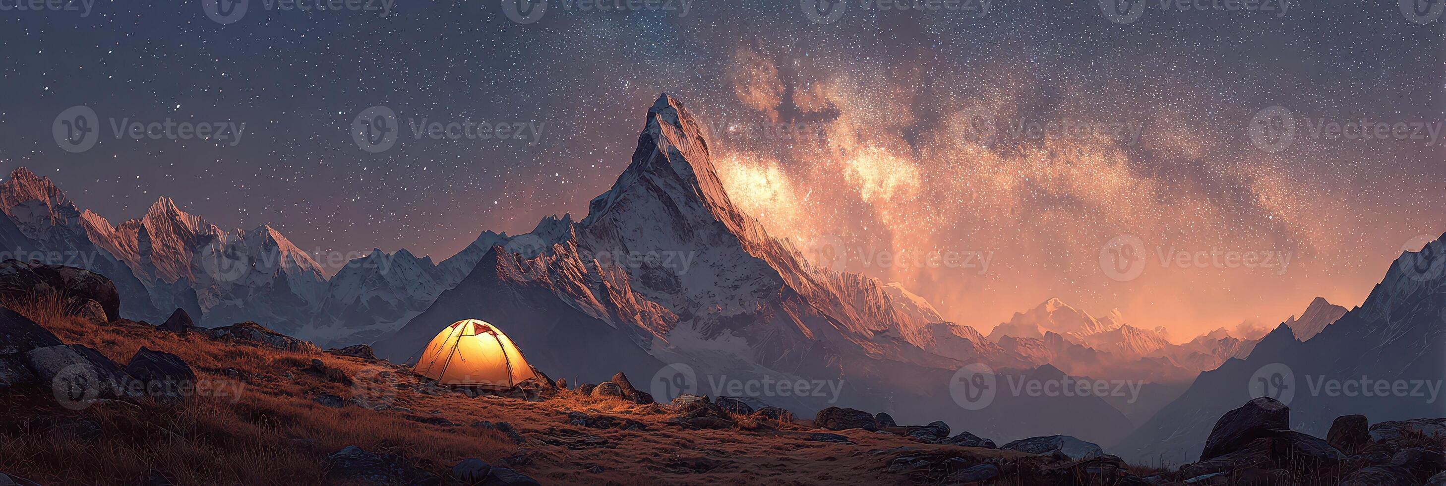 Majestic mountains and a glowing tent under a starry sky at night photo