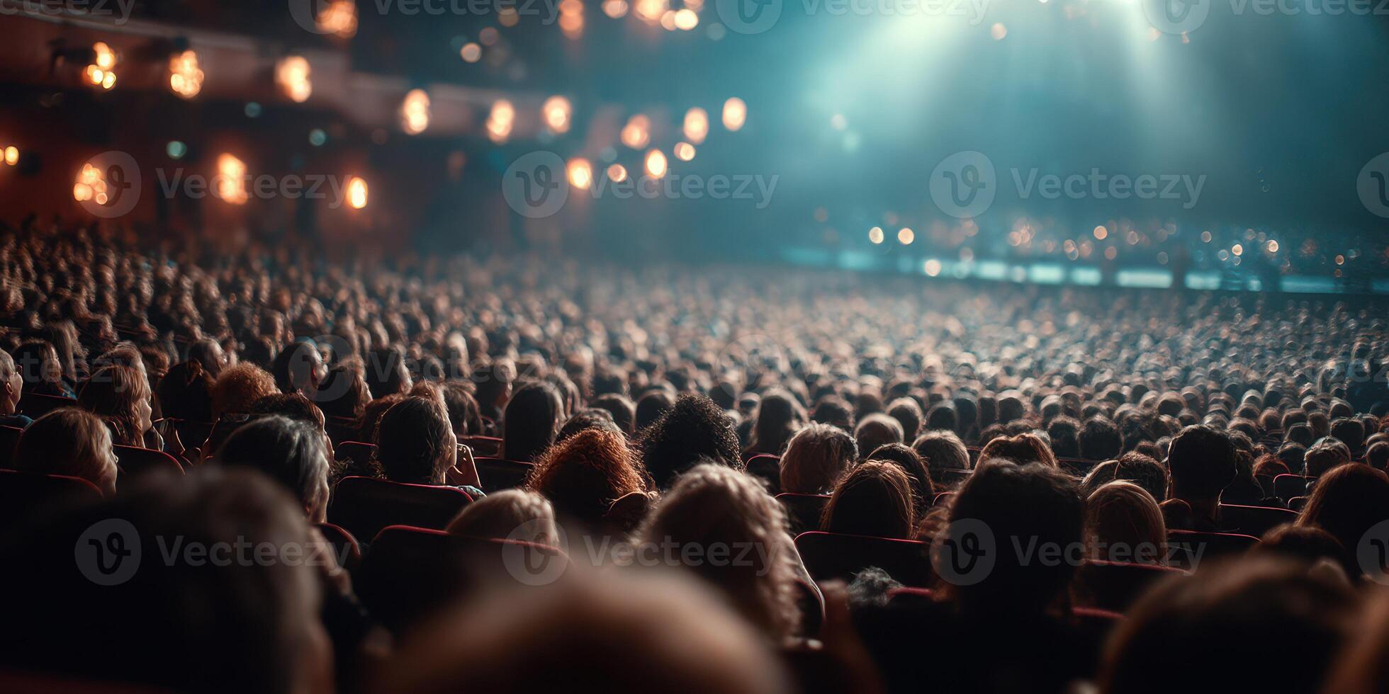 Crowd of spectators enjoying a live performance in an elegant theater setting during the evening photo