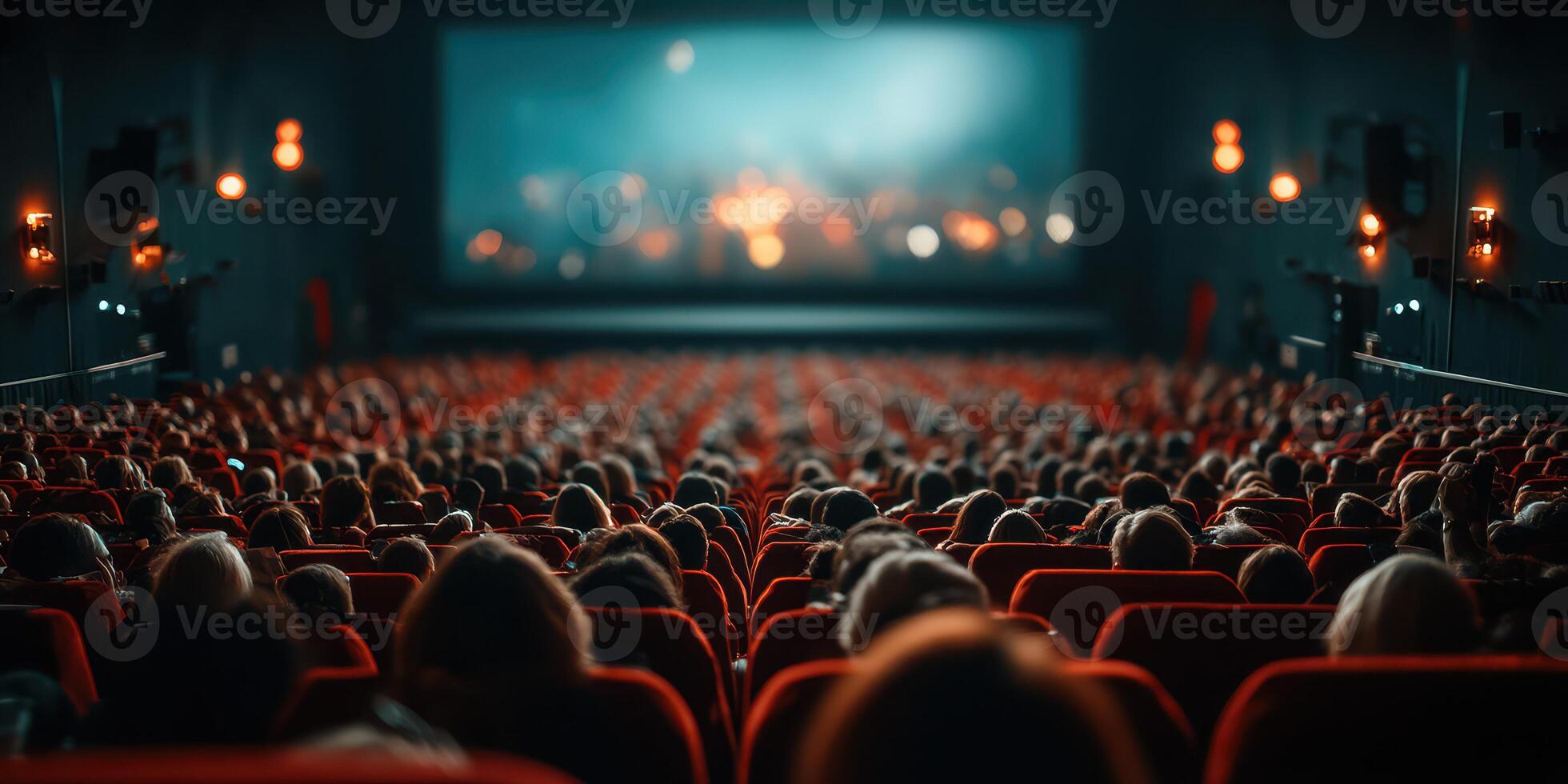 Crowd watching film in a theater with dimmed lights and vibrant screen display photo