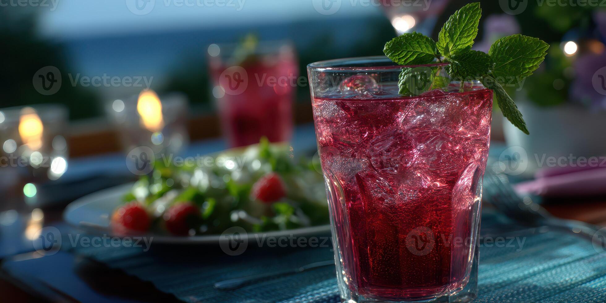 Refreshing drink with mint and salad by ocean at dusk during a summer gathering photo
