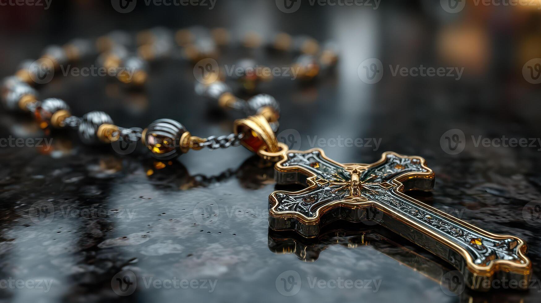 Ornate golden cross pendant resting on black marble counter illuminated by soft light photo
