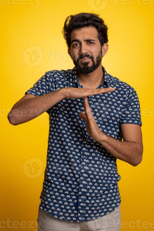 Tired serious upset indian man showing pause gesture, stop sign, time out, relax, break, deadline photo