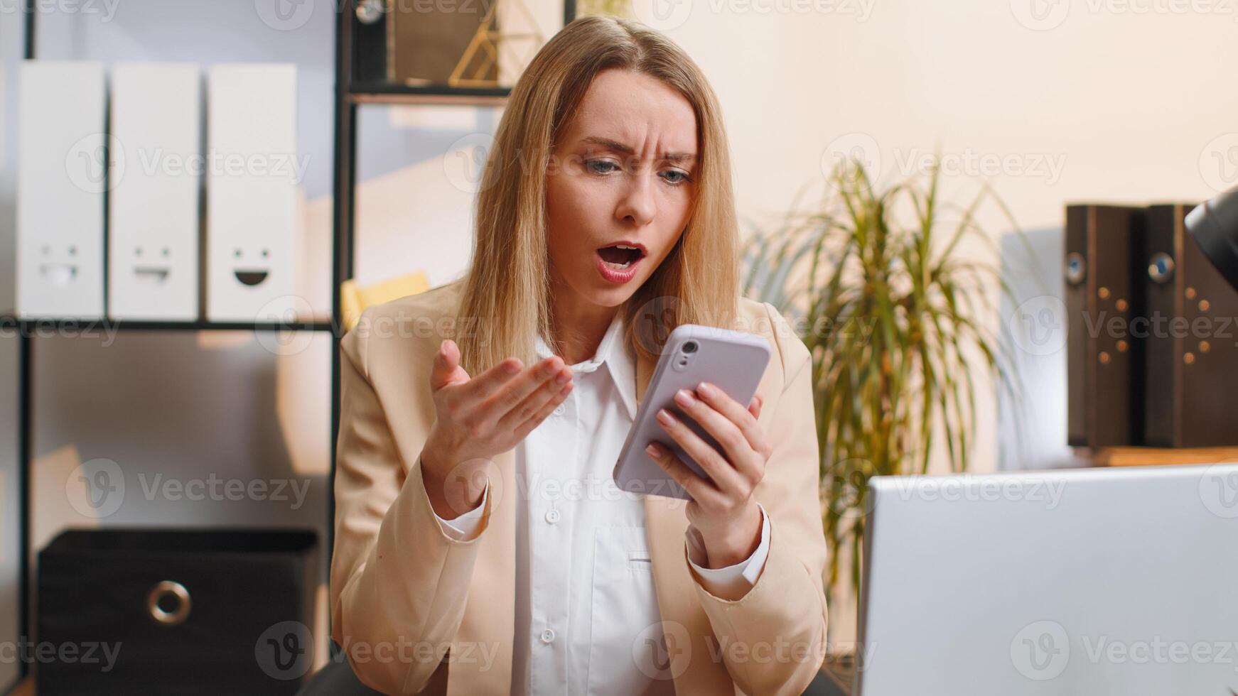Young office business woman use smartphone surprised by bad news, fortune loss, fail lottery results photo
