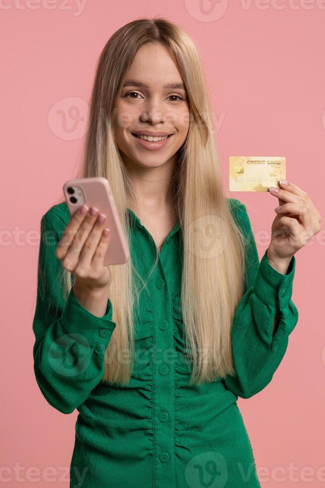 Happy woman using credit bank card and smartphone while transferring money purchases online shopping photo