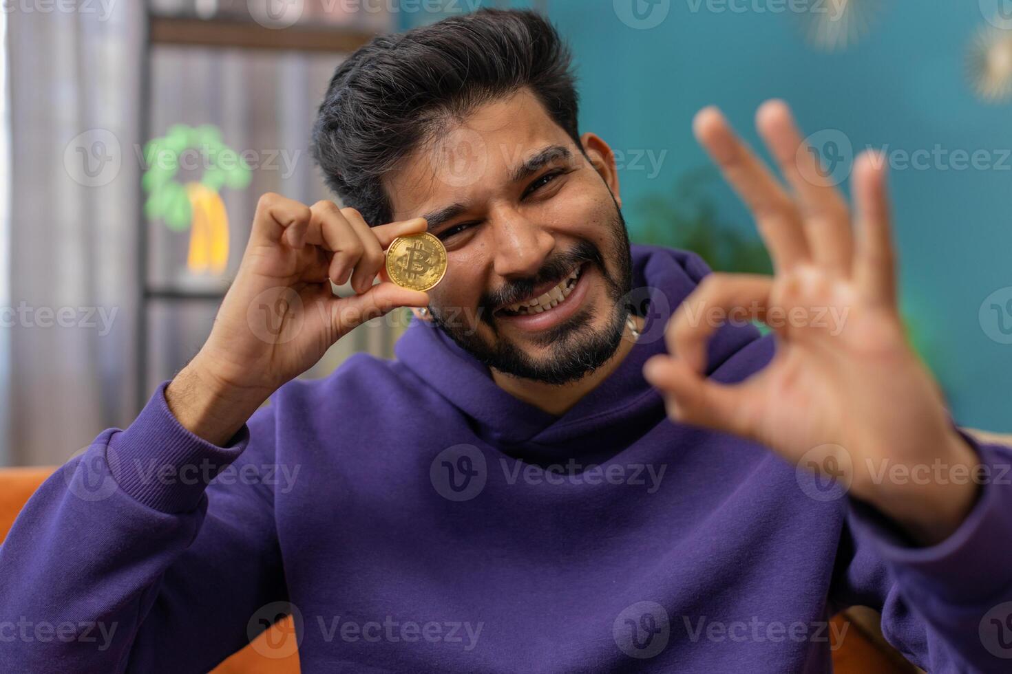 Indian man stock trader earning bitcoins, online monitoring trading operations mining hold BTC coins photo