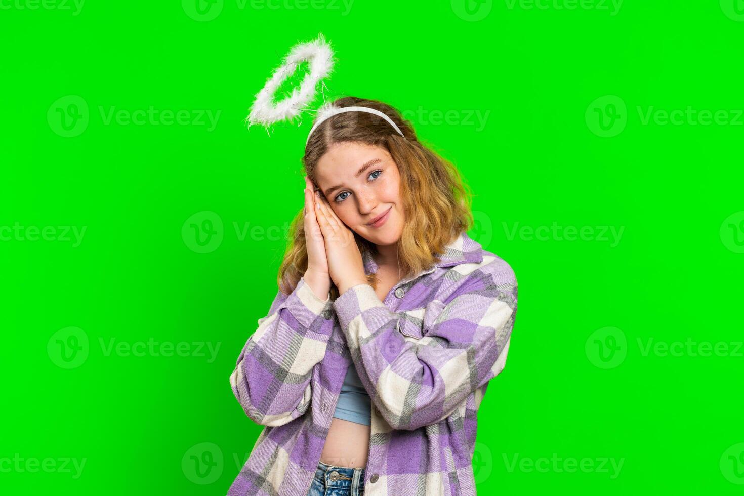 Portrait of smiling shy angelic young woman with angel halo nimb over head, positive love emotions photo
