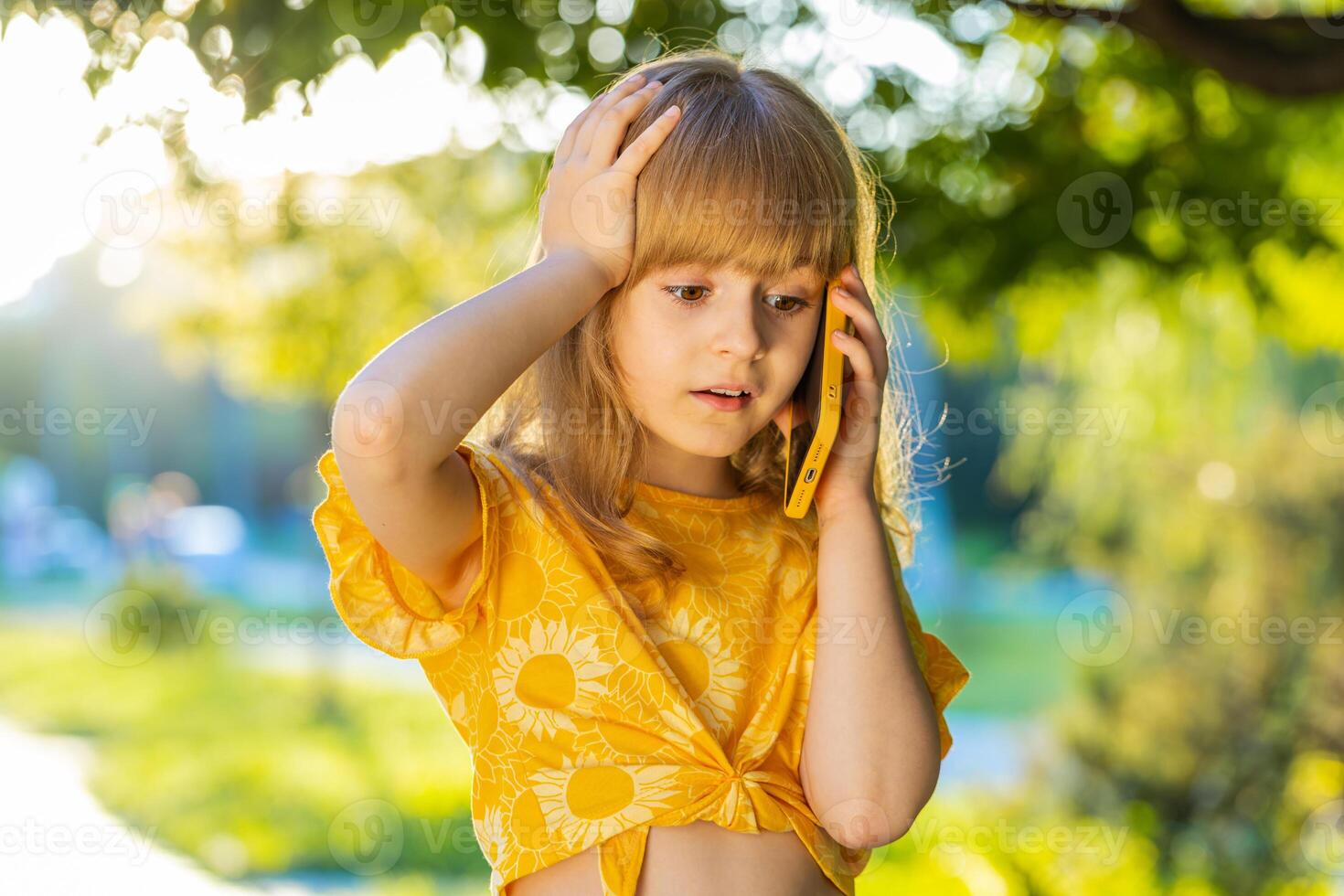 Confused child girl having remote conversation quarrel talking on smartphone gossip on city street photo