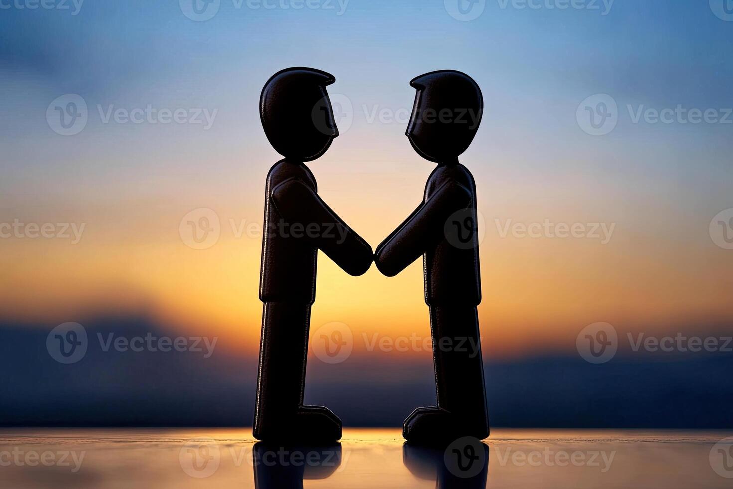 Two figures shaking hands at sunset photo