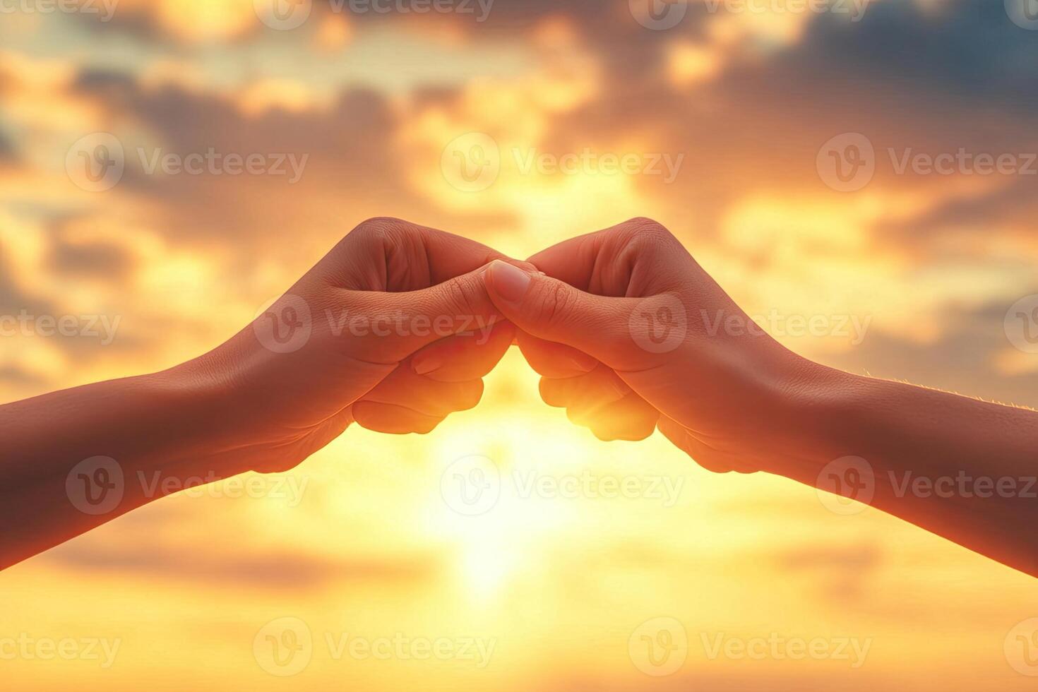 Two hands clasped in a powerful gesture against a dramatic sunset photo