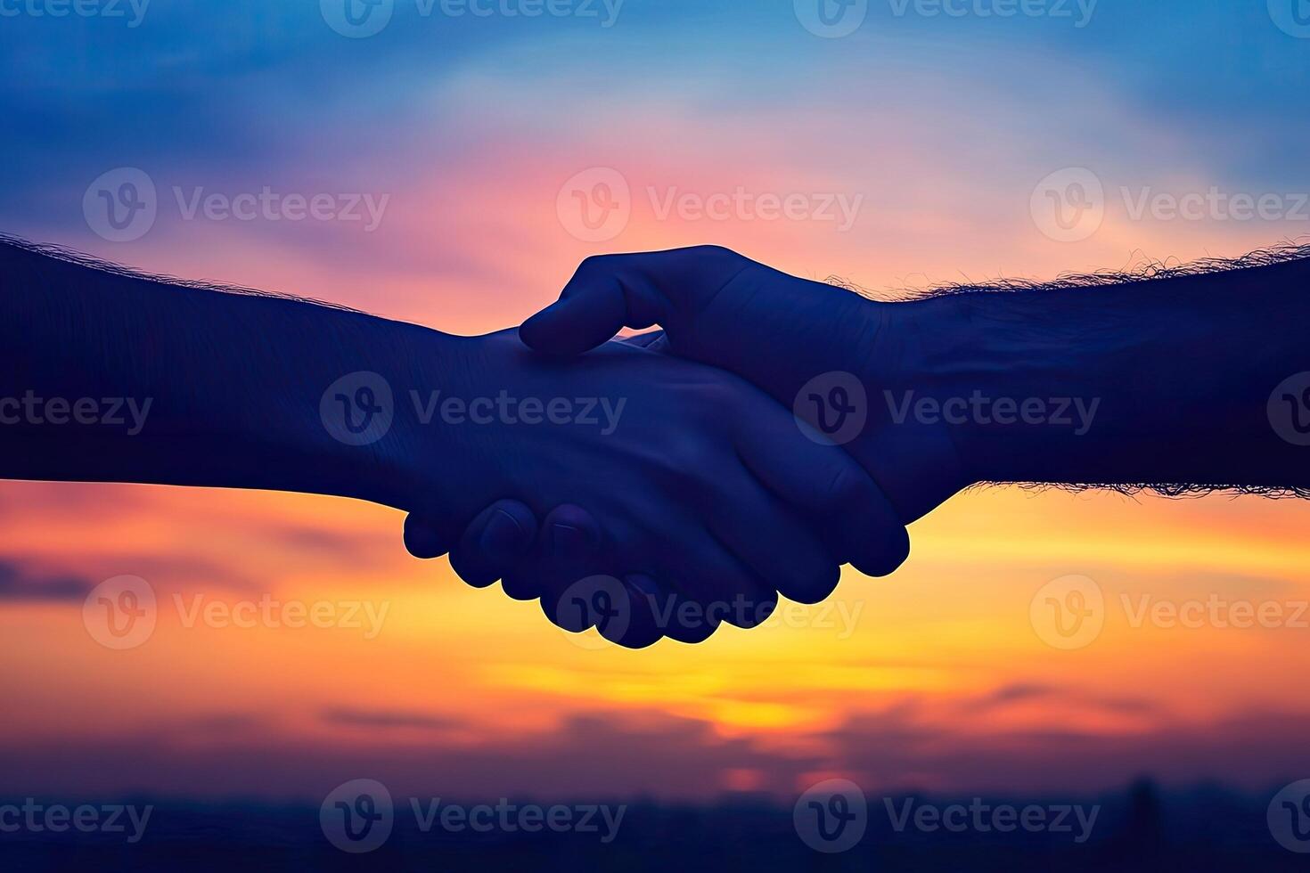 Two hands clasped in friendship at sunset photo