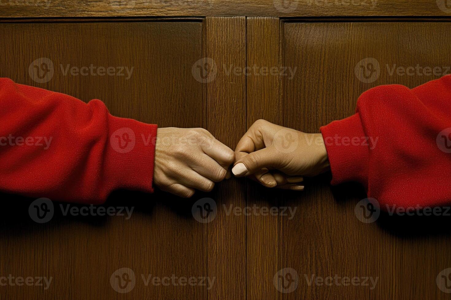 Two hands clasped in solidarity, adorned in vibrant red photo