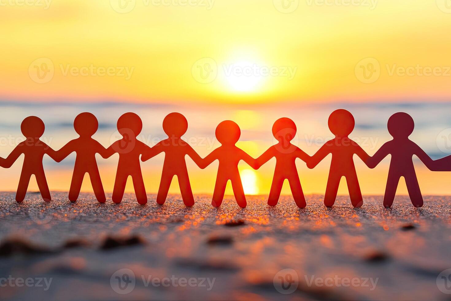 Paper figures linked hands at sunrise photo