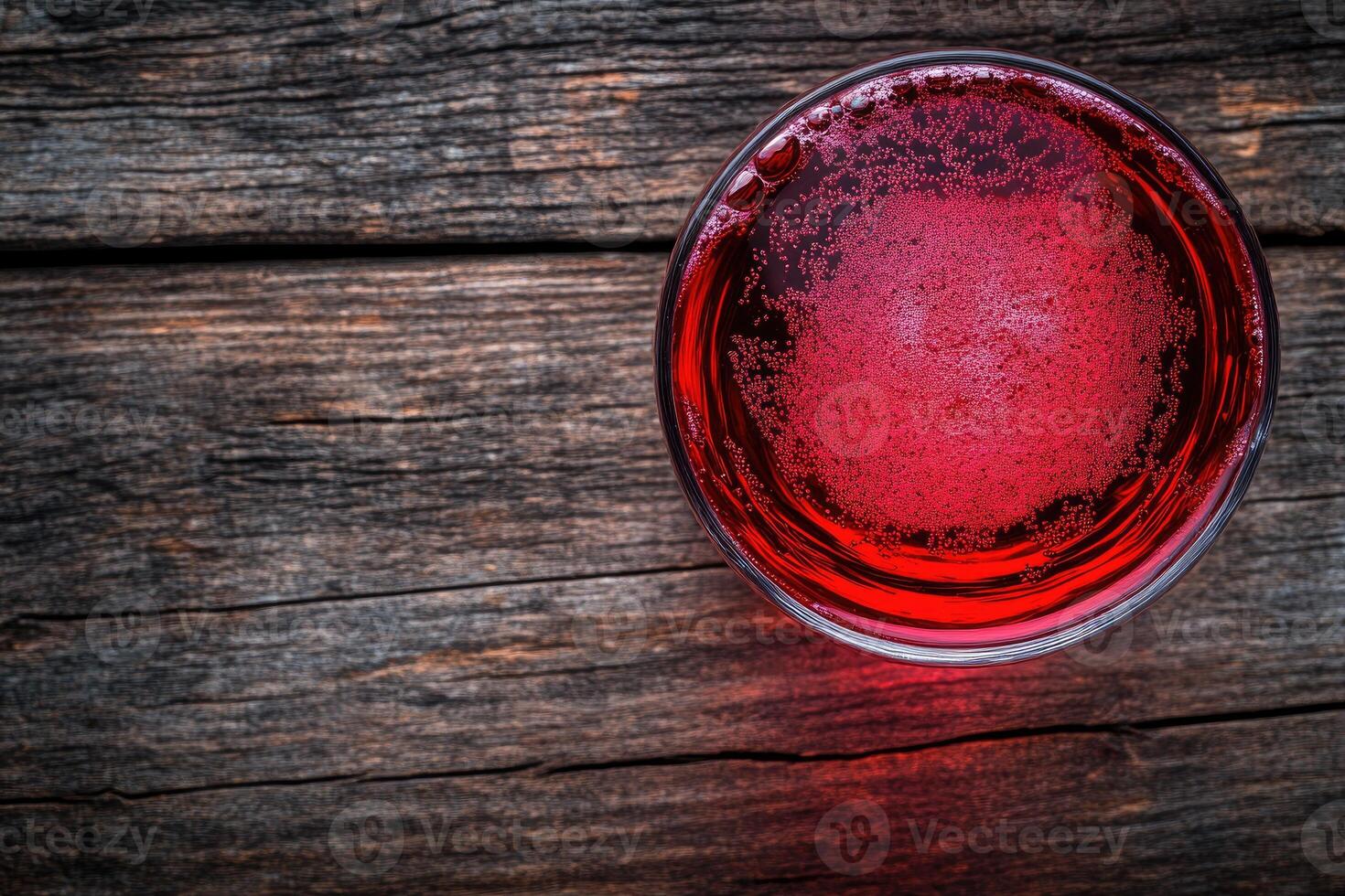 Red Drink in a Glass on Wooden Surface photo