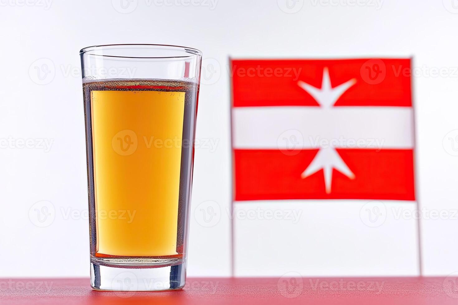 Shot glass of amber liquid, flag in background photo