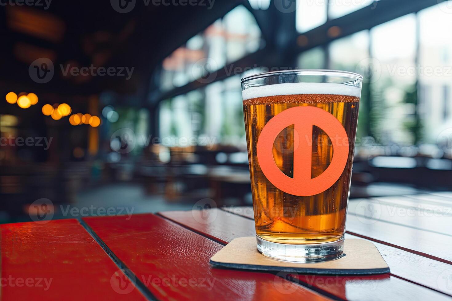 Light amber beer in a glass on a red table photo