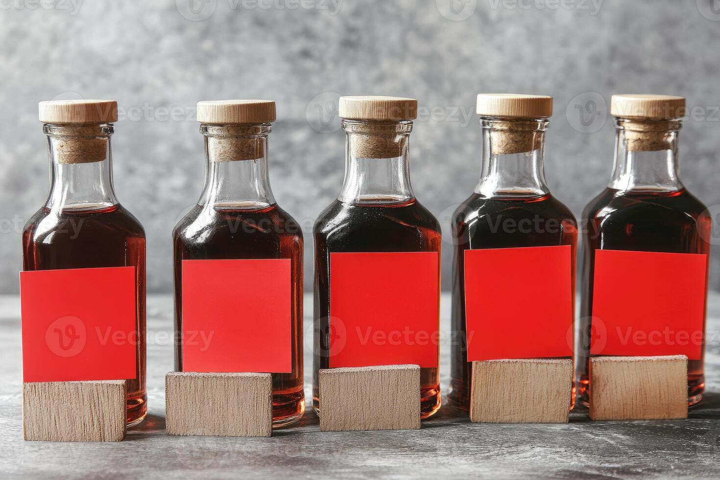 Row of empty dark glass bottles with red labels and wooden coasters photo