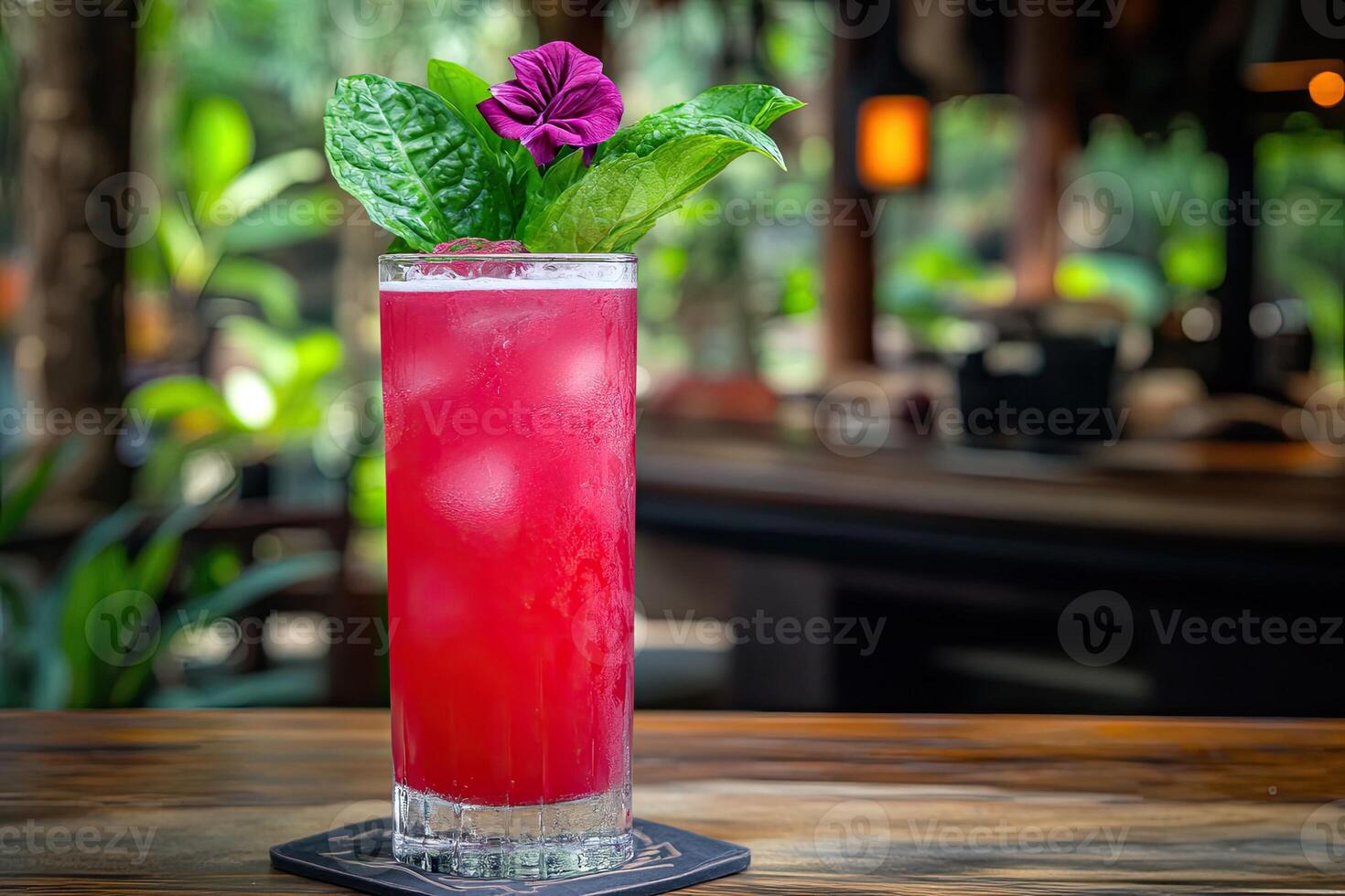 Vibrant pink cocktail garnished with purple flower and herbs photo