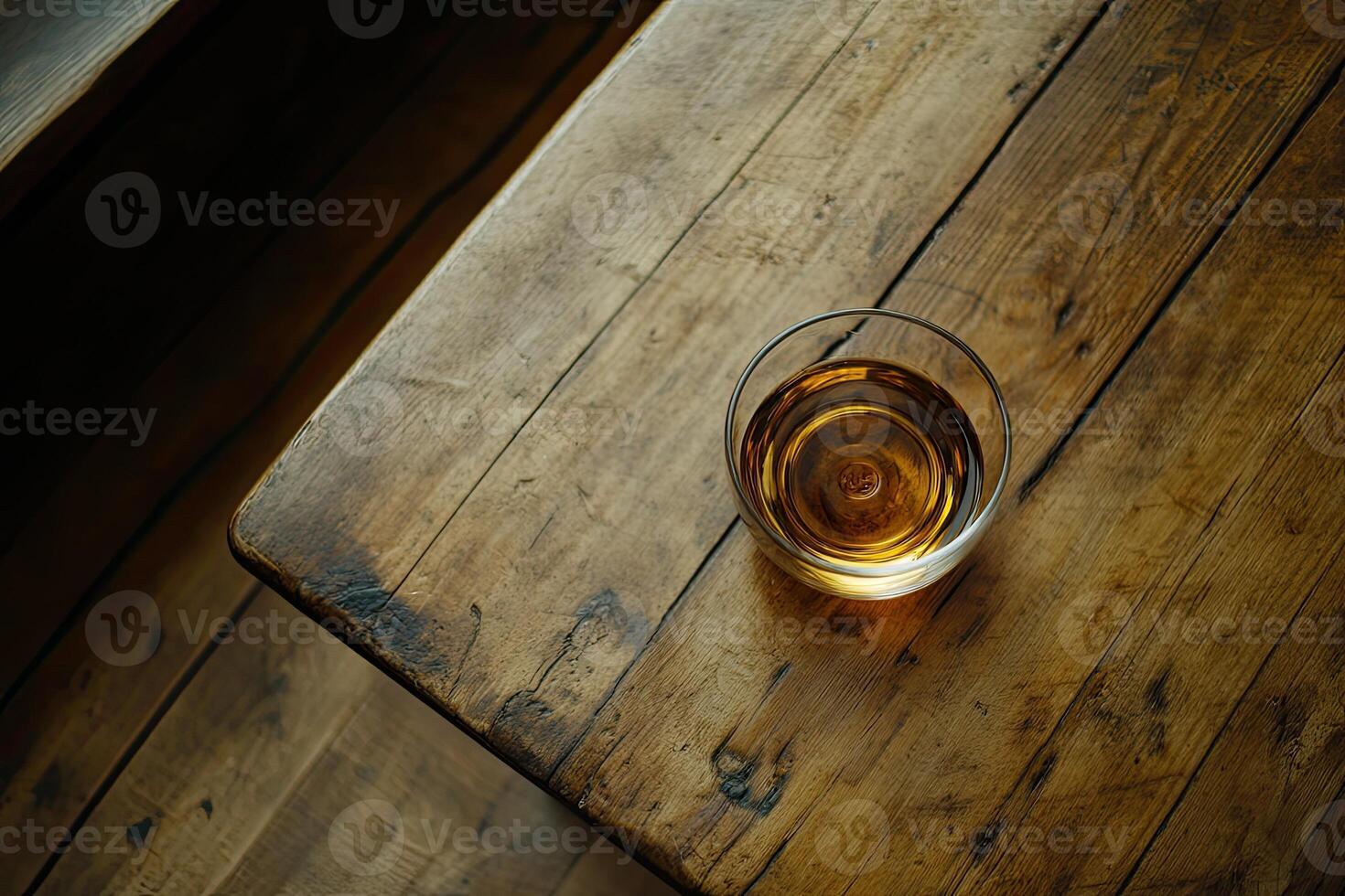 Amber liquid in glass on rustic table photo
