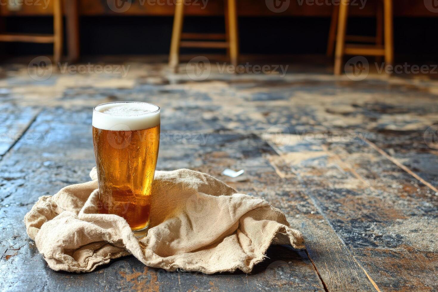 A glass of light beer on a rustic wooden floor photo
