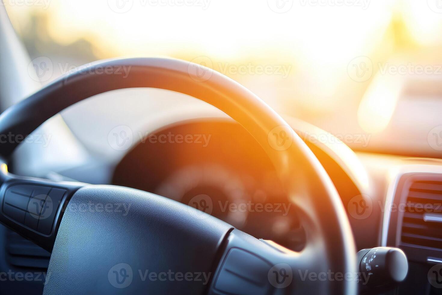 Close-up view of a car dashboard with steering wheel. Sunlight streams into the vehicle's interior photo