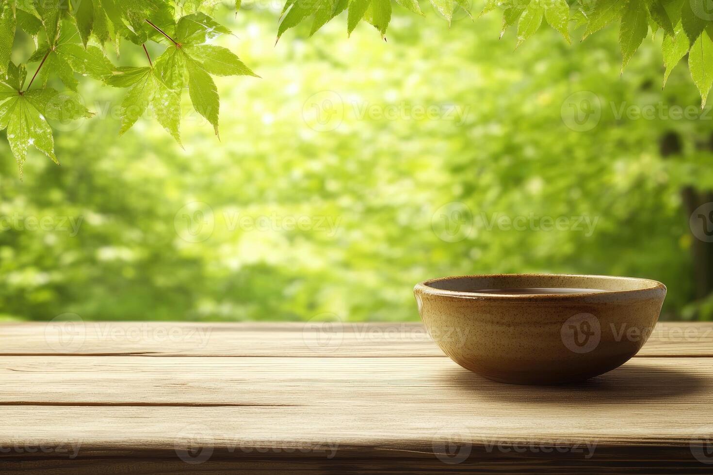 Tranquil bowl on wooden table, dappled sunlight filters through lush greenery photo
