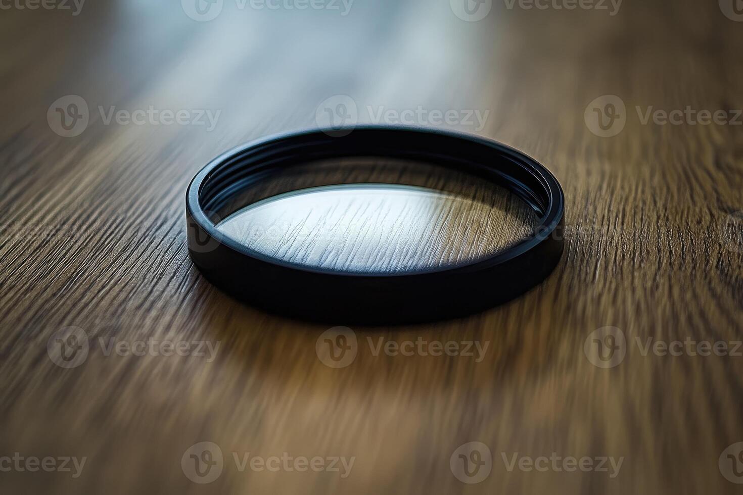 Circular camera lens filter on wooden surface photo