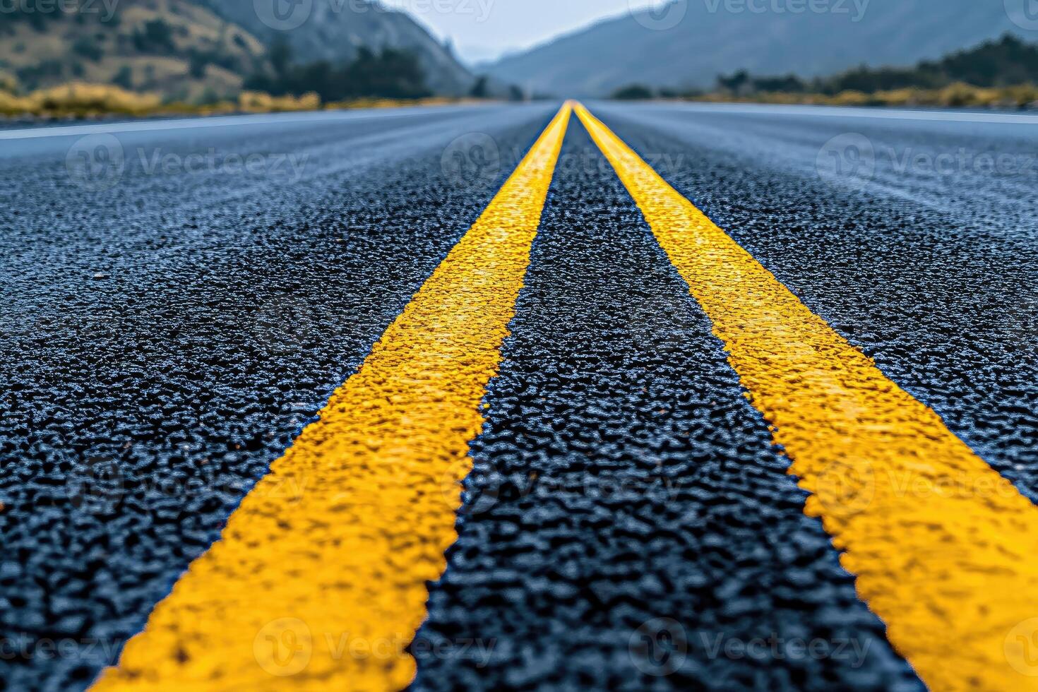 Two yellow lines on a wet asphalt road photo