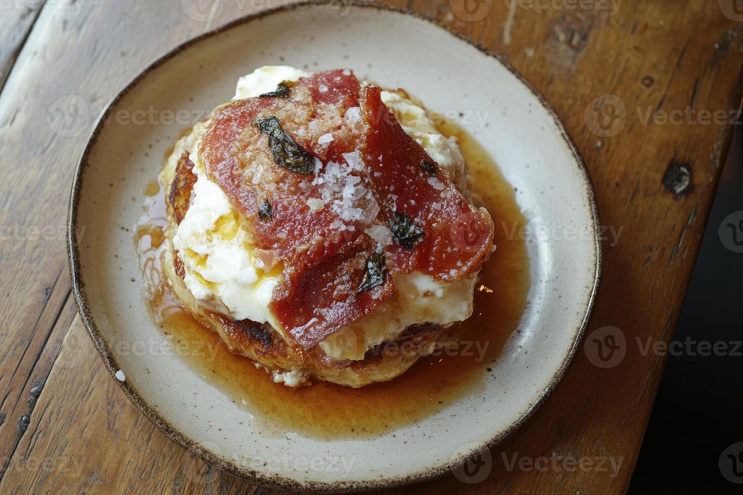 Savory pancake stack with prosciutto, whipped cream, and syrup photo