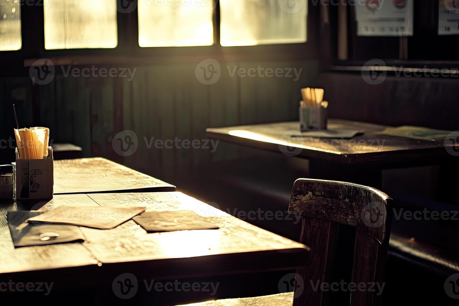 Empty tables in a dimly lit cafe bathed in golden sunlight photo