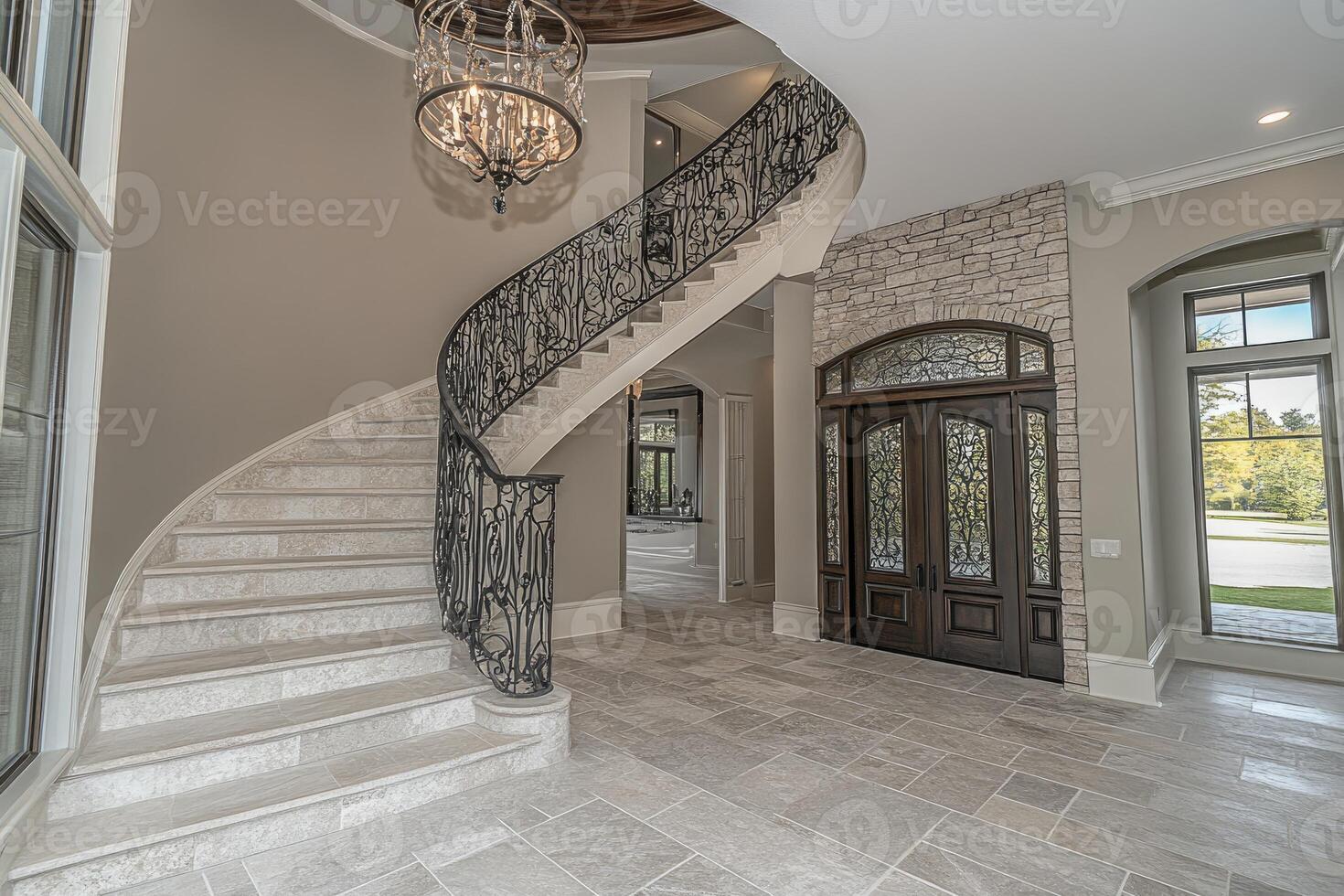 Grand entryway with curved staircase photo