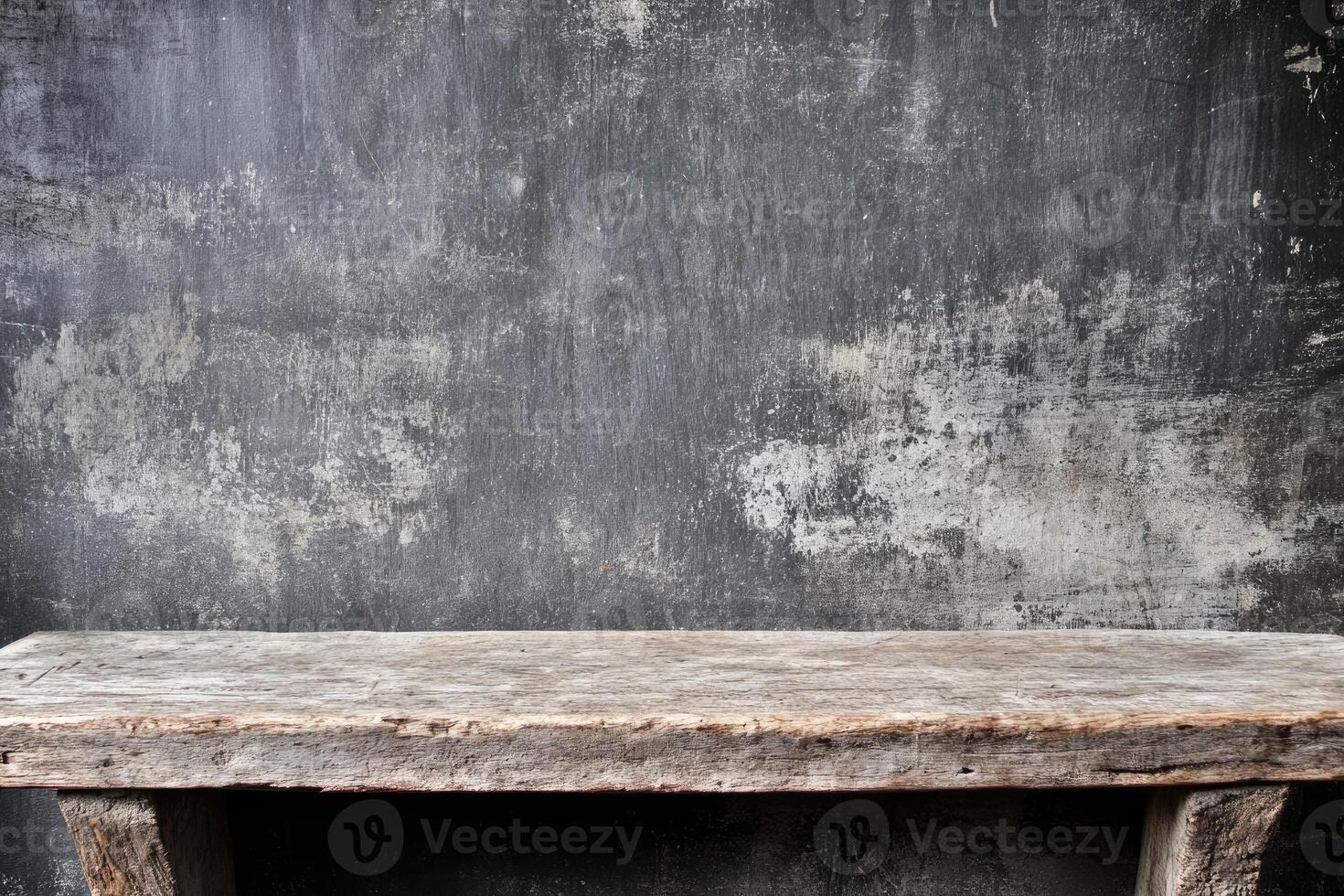 Rustic wooden table against a weathered gray wall photo