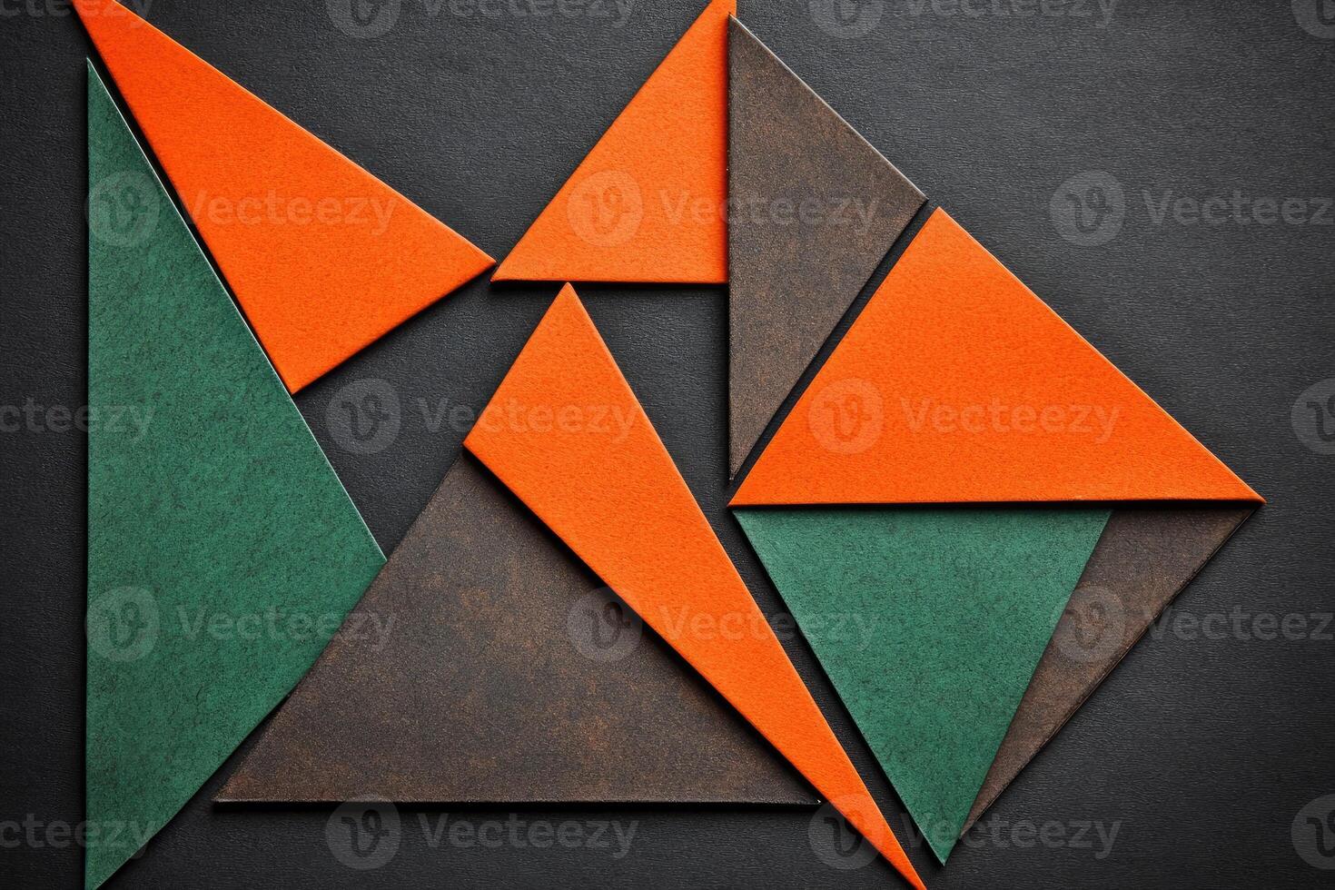 Abstract geometric design composed of overlapping triangles in orange, dark green, and brown hues photo